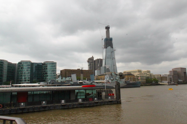 游船停靠在伦敦塔码头，背景高楼是正在建的碎片大厦（The Shard）