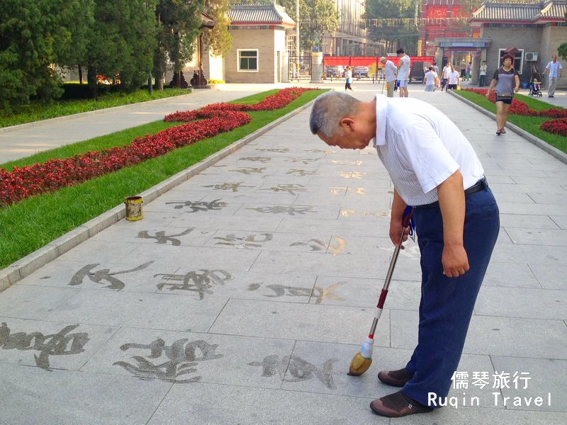  practicing calligraphy on the pavement in Ritan Park