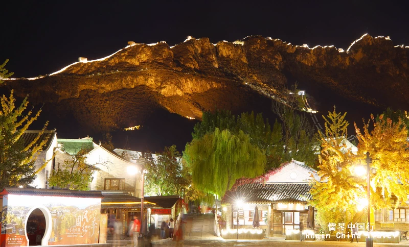 The night view of Gubei Water Town the background of Illuminated Simatai Great Wall