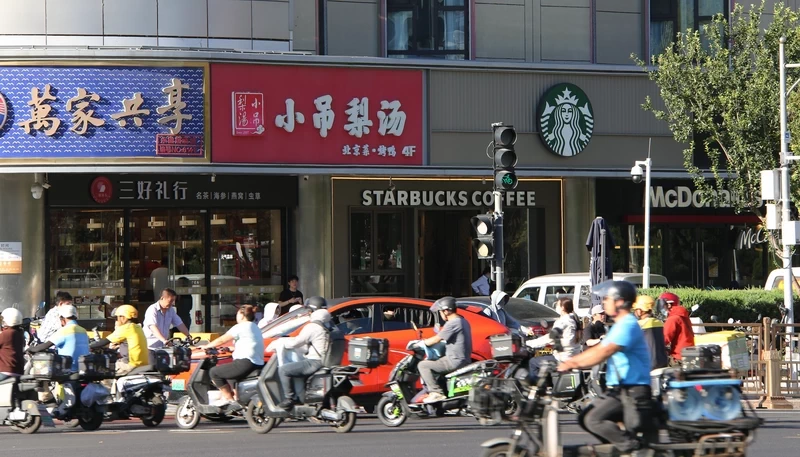 Delivery riders moved constantly through the scene on JIanguomenwai Dajie