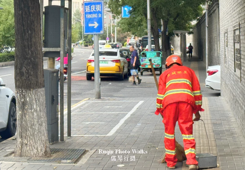 I noticed a municipal worker quietly sweeping the sidewalk in Beijing
