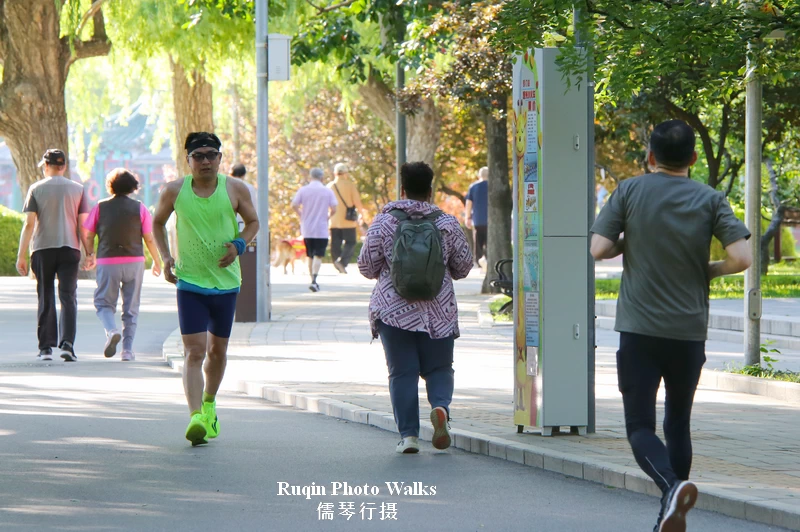 People jogging or walking at a steady pace along the loop path in Longtan Lake Park