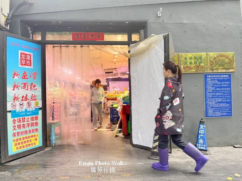 The side entrance to Longtan Morning Market and local shoppers arriving for the day