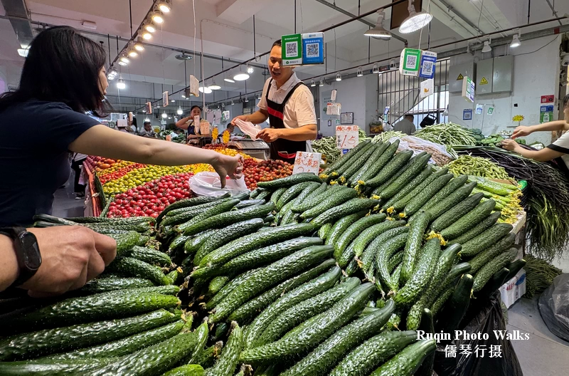 Nearby, cucumbers lay in tidy rows at Longtan Market Beijing