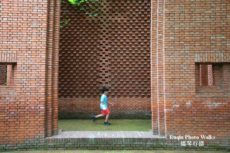 It behaves more like a sequence of partial framings in the courtyard of Red Brick Art Museum