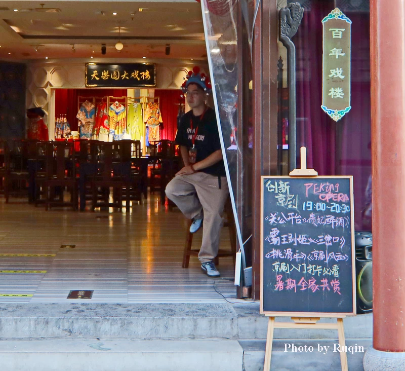 The handwritten Peking Opera performance schedule at the entrance to Tianleyuan Theatre